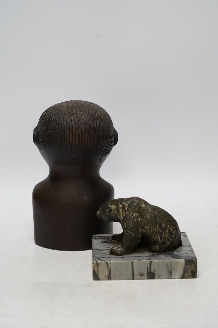 A bronze polar bear paperweight and an African tribal carved wood bust, 17cm high. Condition - fair, some splits to the bust